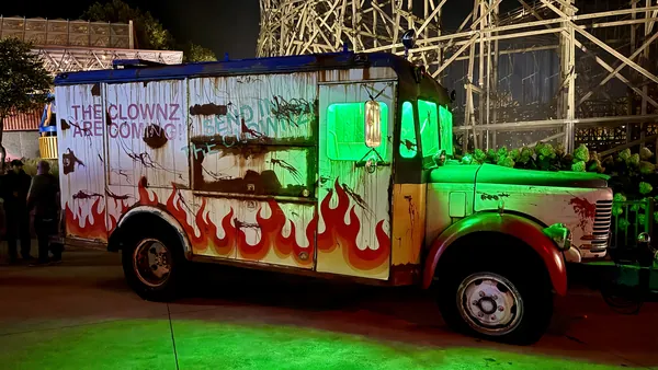 Flame-painted box truck lit acid green in the Clownz scare zone at Cedar Point