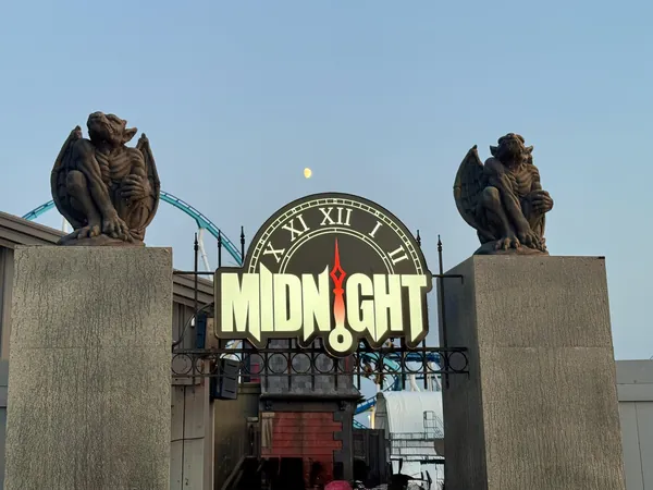 The Midnight maze entrance at Cedar Point: a clock face reading midnight between two stone gargoyle plinths